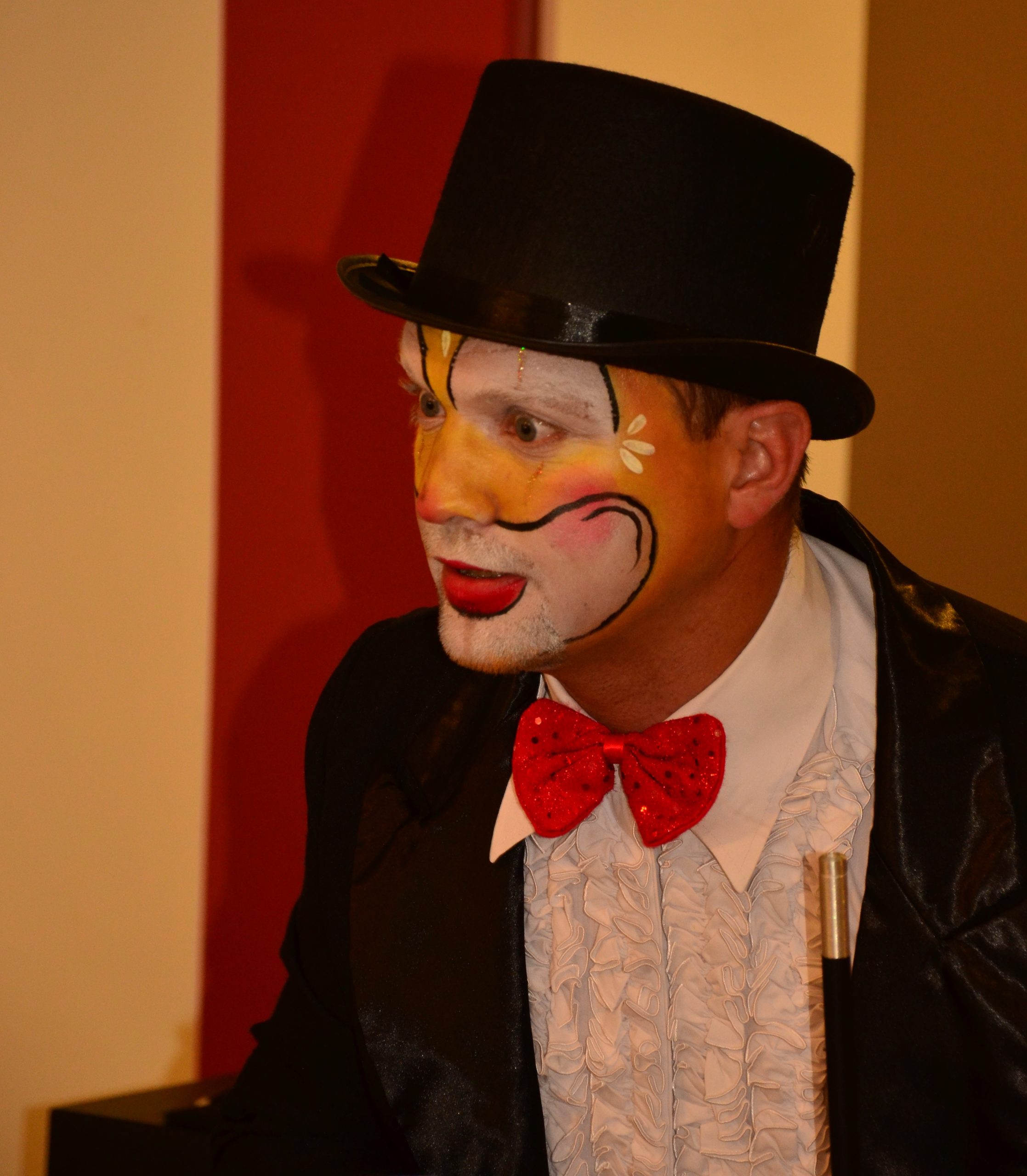 Magic Clown Jimmy met een clown gezicht gesminkt kijkt naar links