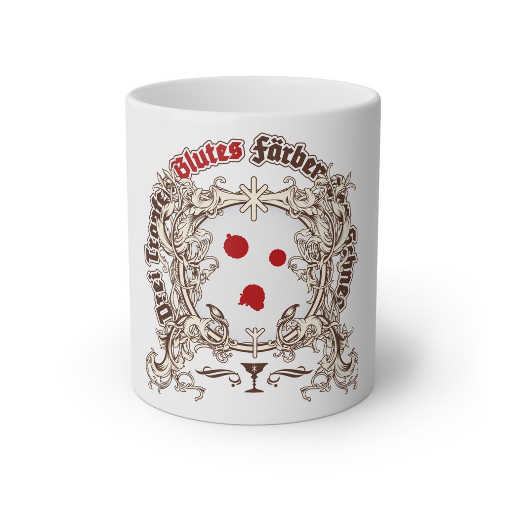 A white ceramic mug featuring a bold design inspired by esoteric and mythological themes. The centerpiece is an ornate frame of intricate scrollwork, within which appear three striking red drops of blood against a stark white background. Above the frame, the German text "Drei Tropfen Blutes färben den Schnee" is written in gothic-style red and black lettering. Below the frame is a chalice symbol, subtly decorated, adding to the mysterious and symbolic aura of the design. The overall aesthetic blends gothic and medieval motifs with a modern, enigmatic touch.