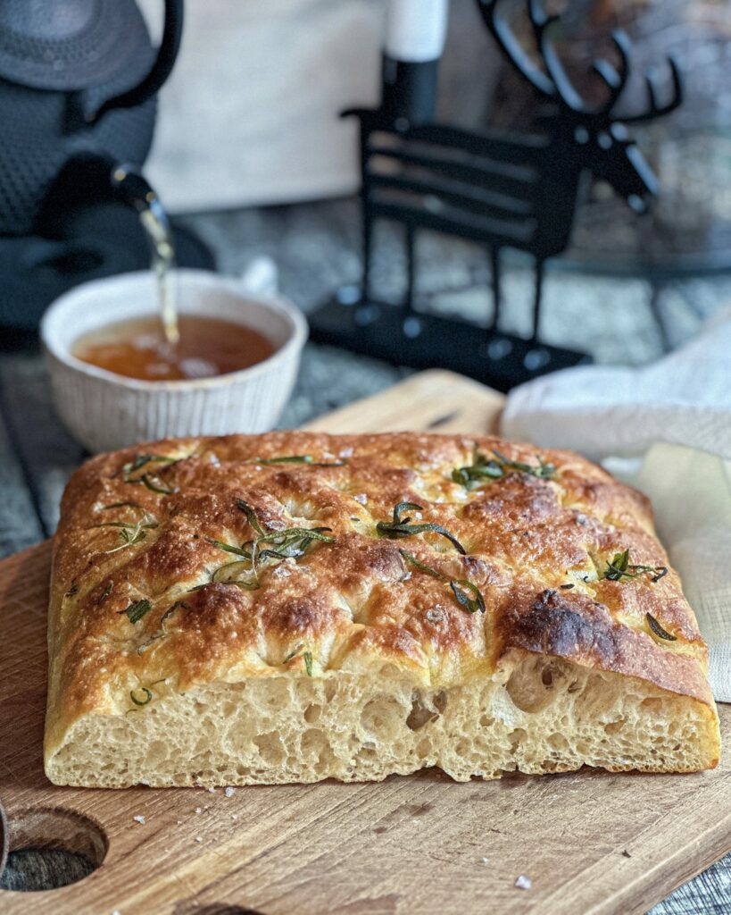 Focaccia med sprød skorpe og store lufthuller toppet med rosmarin og flagesalt