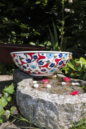 Farverig keramik skål med røde og blå blomstermotiver på en hvid baggrund. Blyfri håndlavet kvalitet perfekt til salater eller frugt