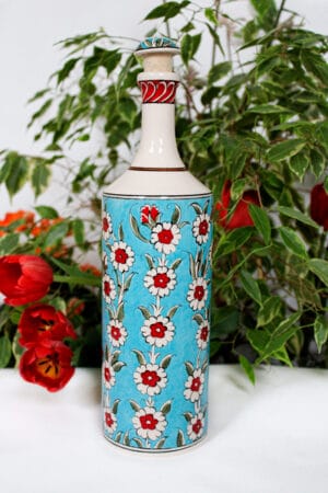 Håndlavet keramik flaske til olier. Røde og hvide blomstermotiver på flot turkis baggrund og håndmalet låg.