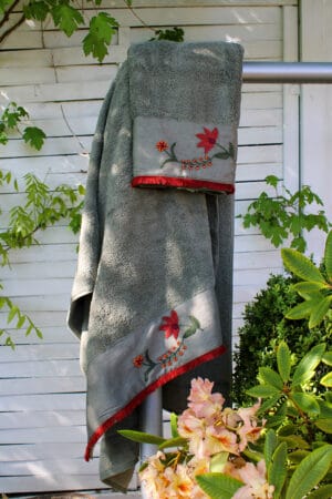 Eksklusive håndklæder i flot olivengrøn farve med en bort med skønne røde håndlavede blomsterbroderier forneden