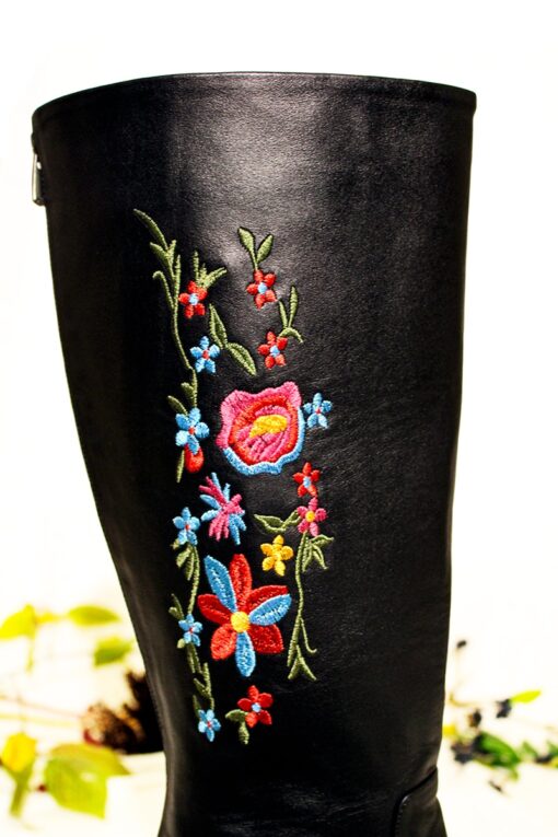 Colorful embroidery of flowers decorating long black boots