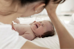 crying baby with worried mother