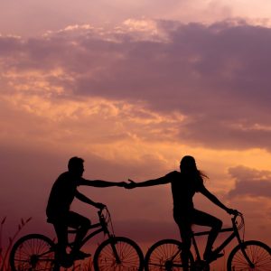 two_people_biking_in_sunset