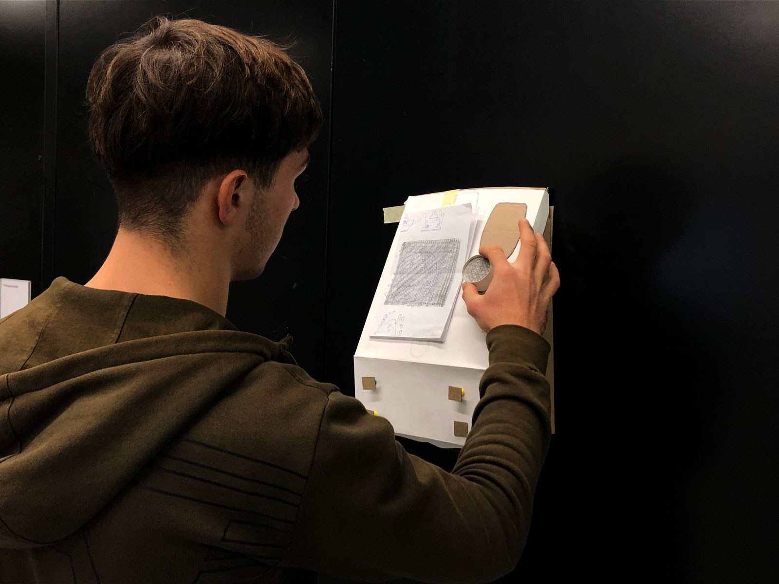 A man interacting with a paper prototype.