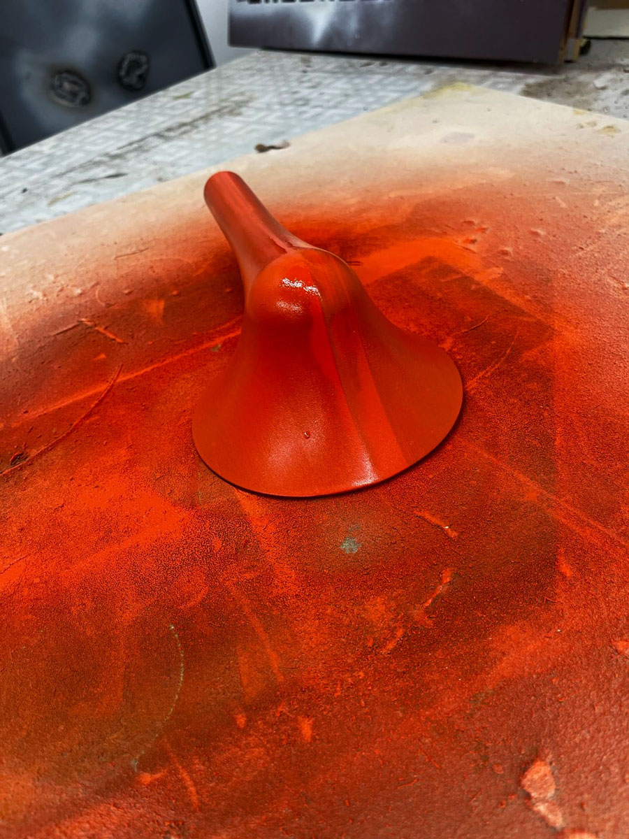A microphone on the table that was recently spreypainted orange.