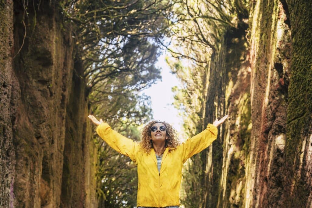 Femme heureuse lève les bras dans la nature