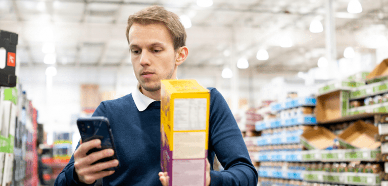 Mann mit Smartphone im Supermarkt