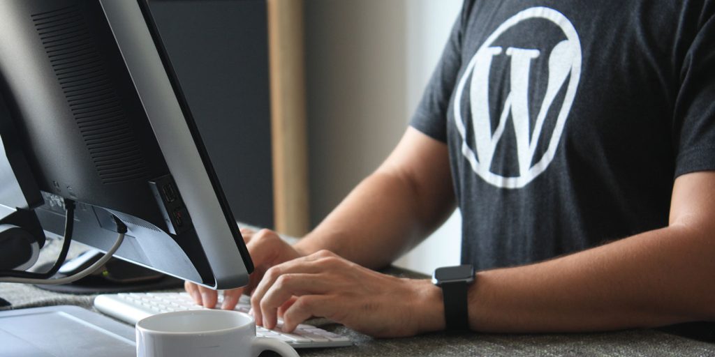 Mann am Laptop mit WordPress T-shirt