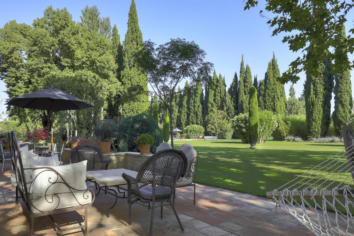Shaded terrace with seating and hammock.