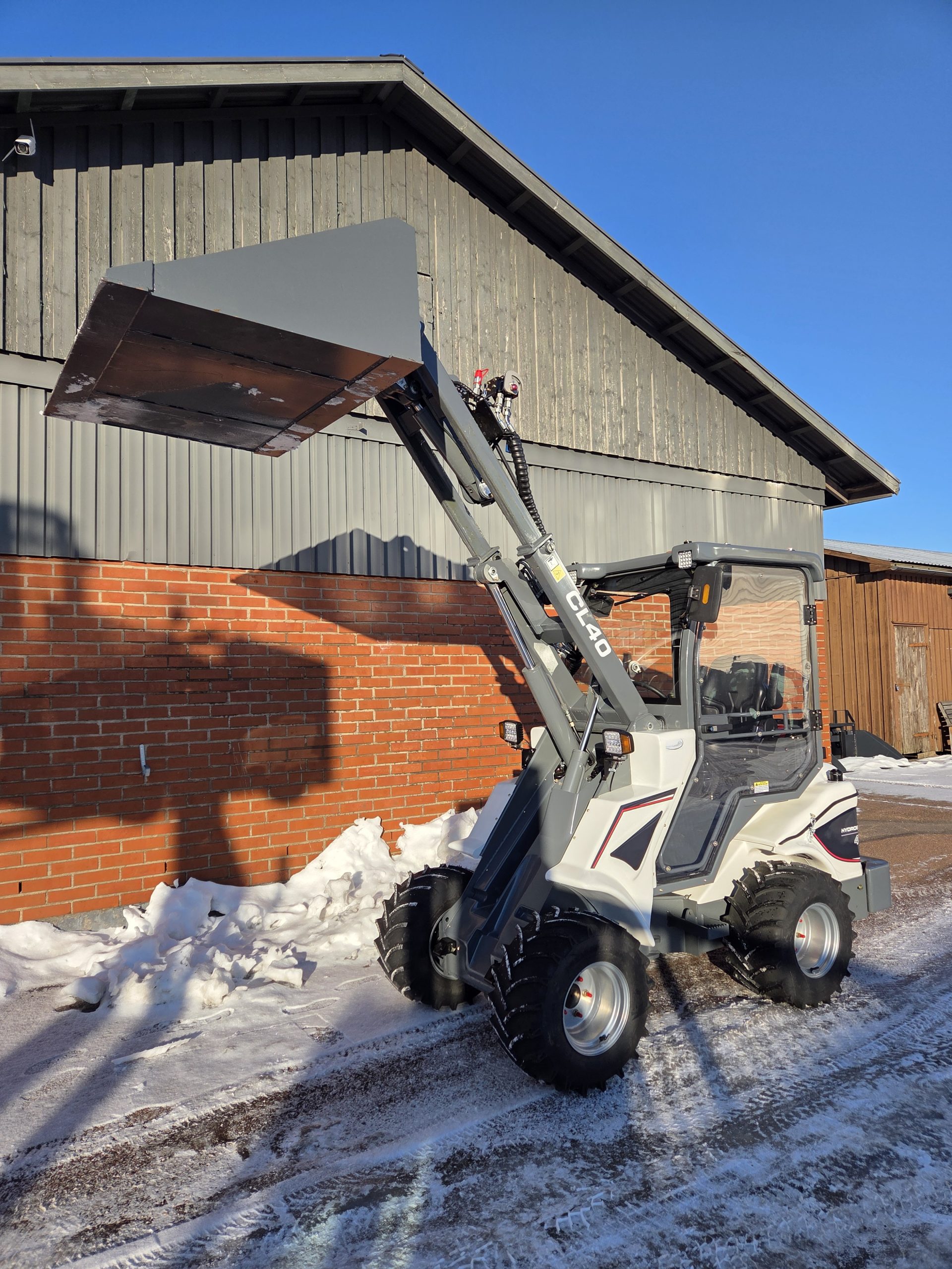 Vit teleskoplastare Taian CL40 från sidan. Hjullastare. Entreprenadmaskiner. Maskiner. Hytt. Däck. Ratt. Joystick. Maskinlagret i Värmland. www.maskinlagret.se