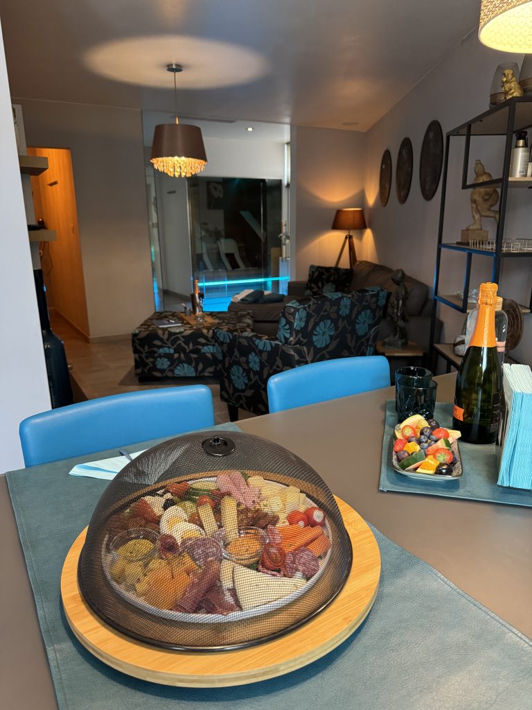 Tapas dish and small bowl of fresh fruit with the seating area of ​​spa dil-zen in the background