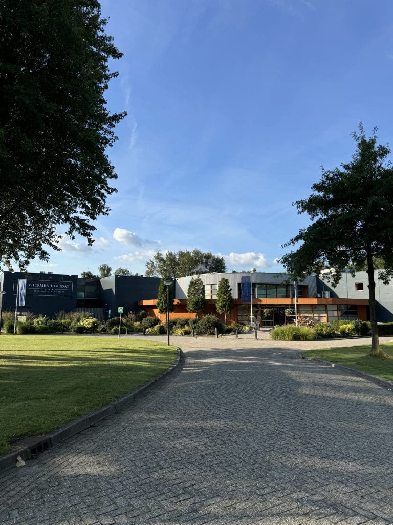 A front view of the entire building of Thermen Holiday in the Netherlands photographed from the street on a sunny day.