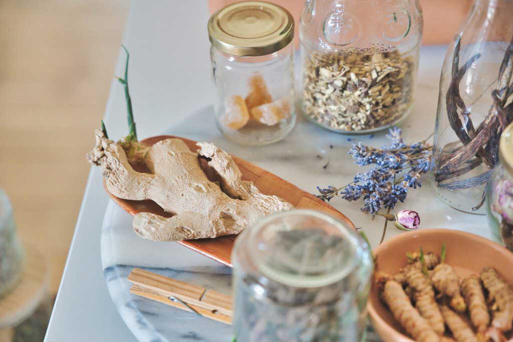 naturopathic medicine and herbal remedies on the table, we see ginger lavender, frankincense and chamomile ready to heal your body!