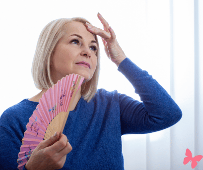 Menopausal woman fanning herself during a hot flash, knowing that thee are natural solutions she could be using to make her life easier