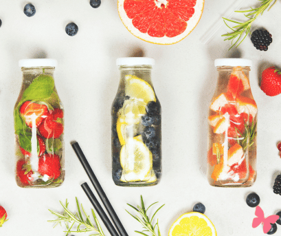 The importance of staying hydrated even in winter - infused water bottles, one with strawberries, one is blueberries and lemon wedges, and one has pink grapefruit chunks with rosemary