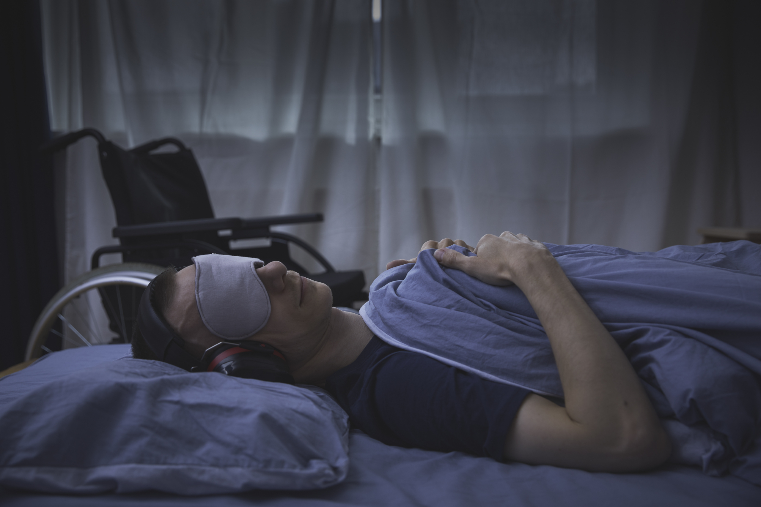 Stockphoto sykeste mann ligger på rygg med maske rullestol bak