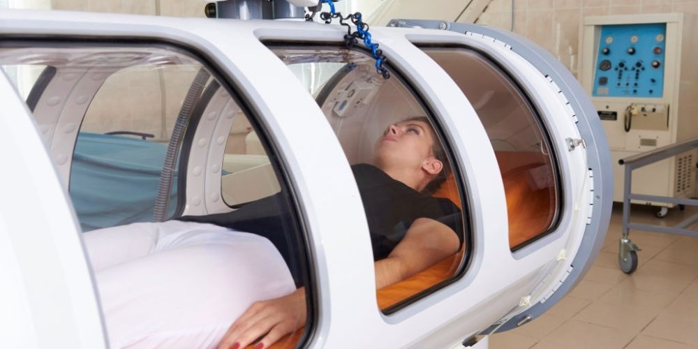 Girl patient lying in a hyperbaric chamber.