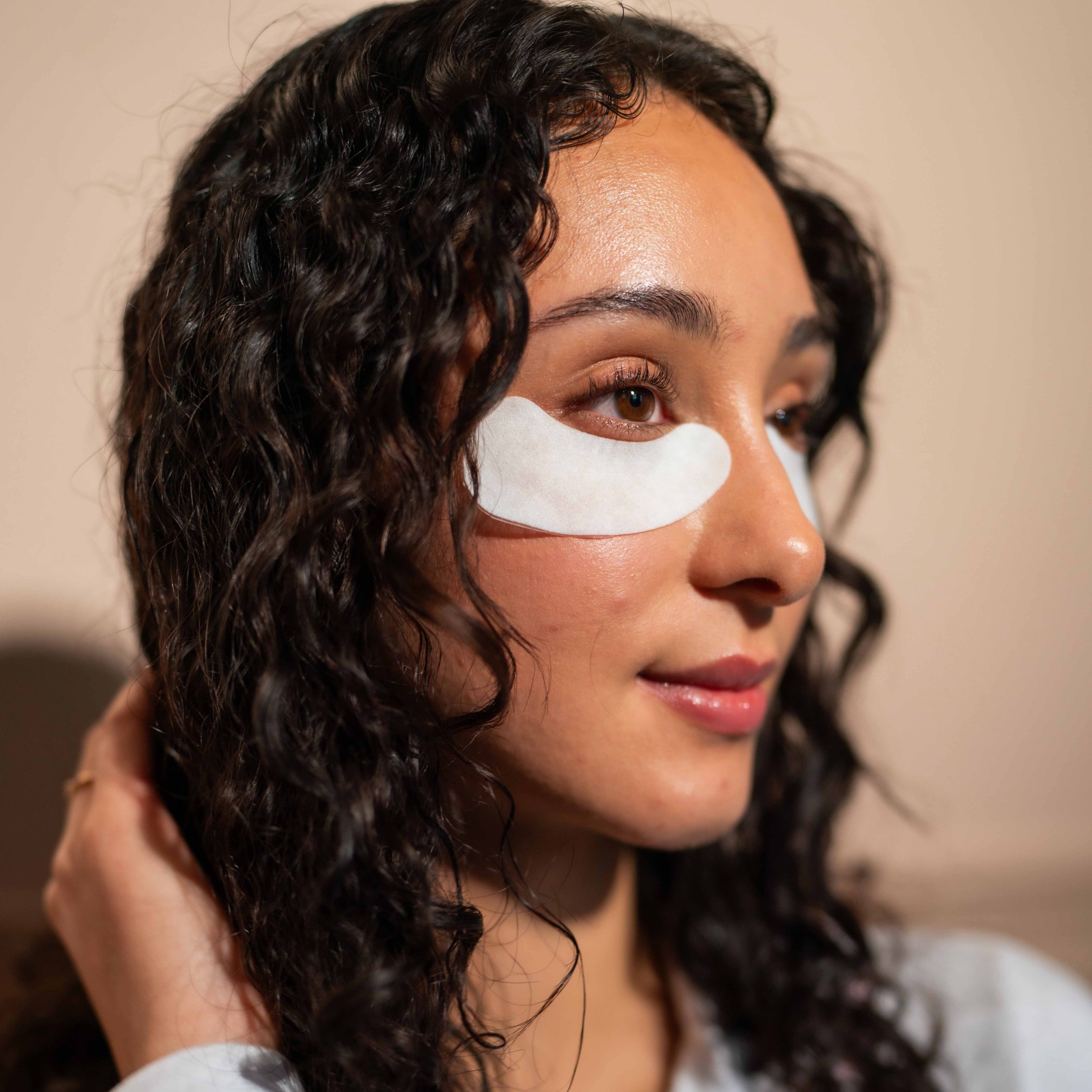 Nærbilde av ansiktet til kvinne med hvite øyemasker etter behandling med Novojet Øyebehandling hos Medskin Beauty