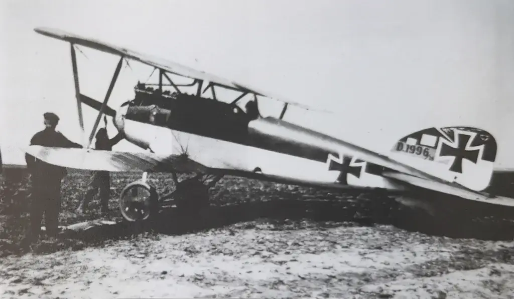 an old airplane with two men standing next to it
