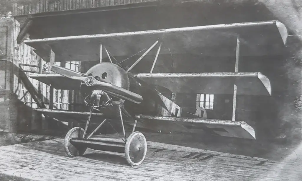 an old photo of a small airplane on a wooden platform