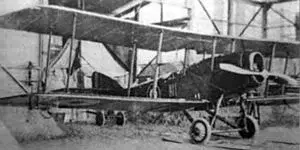 an old airplane is parked in front of a building