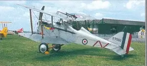 an old airplane sitting on top of a lush green field