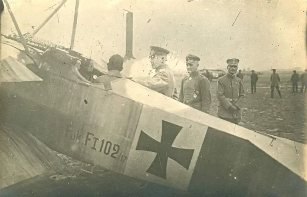 a group of men standing around an old airplane