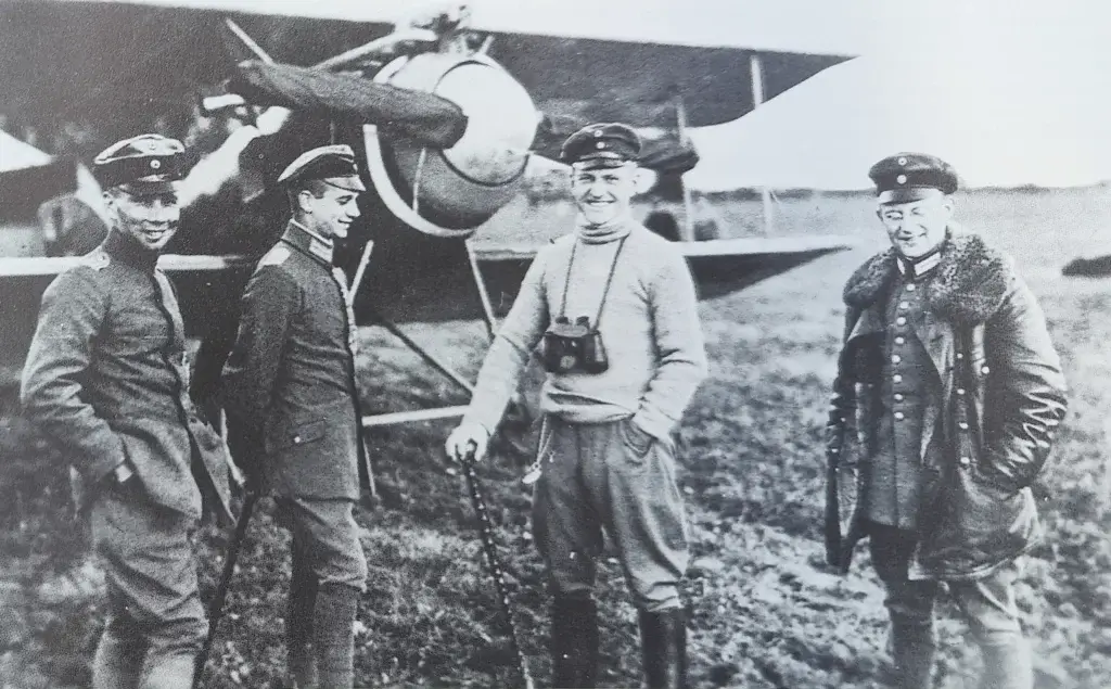 four men standing in front of an airplane