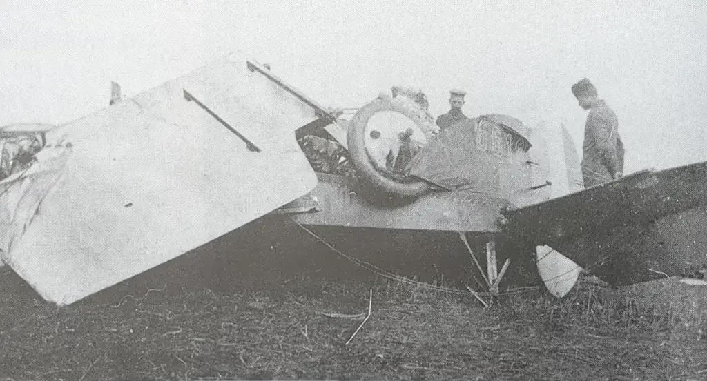 two men standing next to an old airplane