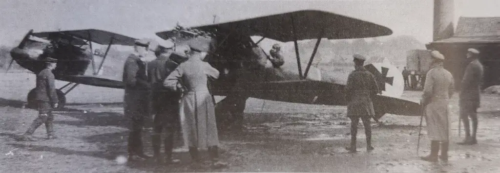 a group of people standing around an old airplane