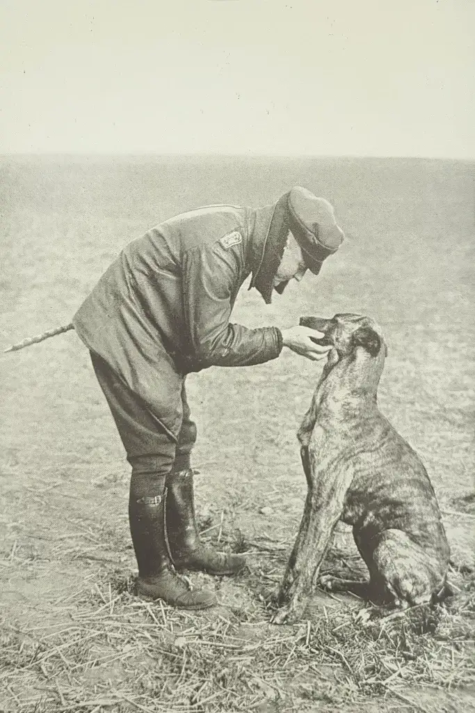 an old photo of a man petting a dog