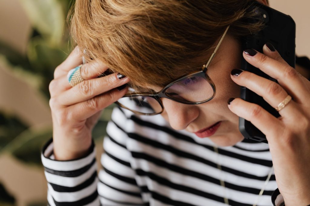 anxious woman having phone conversation in office