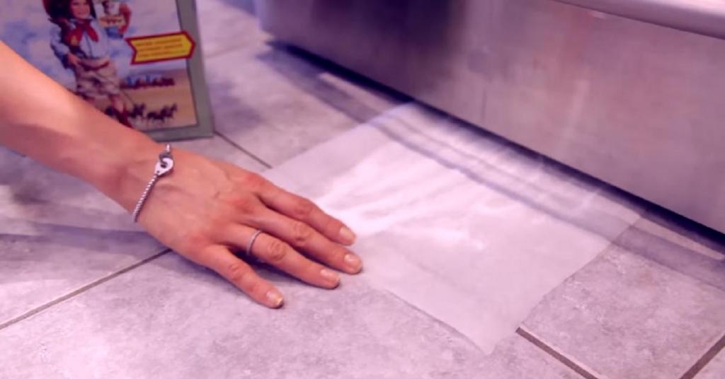 Elle glisse un papier ciré avec du détergent sous son frigo! Regardez bien quand elle le retire! WOH!