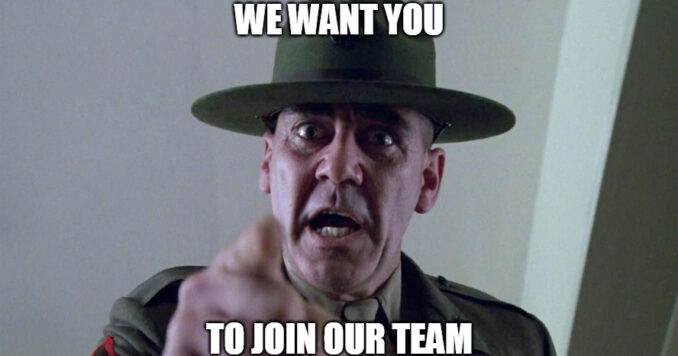 A man in a green military hat and uniform points directly at the camera with a stern, wide-eyed expression. The image has a meme-like quality, with bold white text above and below the man that reads "WE WANT YOU TO JOIN OUR TEAM".