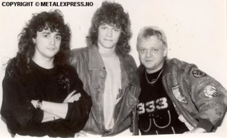 A photograph shows, from left to right, U.D.O. guitarist Mathias Dieth, Metal Express Radio's Stig Nordahl, and U.D.O. vocalist Udo Dirkschneider. All three men are smiling at the camera, with Dirkschneider in a military-style jacket. A "COPYRIGHT © METALEXPRESS.NO" watermark is visible at the bottom.
