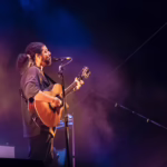 Claudio Sanchez, singer and guitarist of Coheed and Cambria performing live with an acoustic guitar.