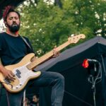 Bass player of Planet Of Zeus performing live. Natural light and tree in the background