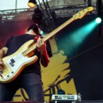 Bass player of Planet Of Zeus performing live. Yellow, green and red ligths.