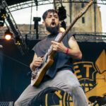 Guitarist of Planet Of Zeus performing live at Kave Fest. In the background behing the stage, you can see the keep of Gisors' medieval castle.