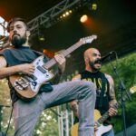 Guitarist and singer of Planet of Zeus performing live. In the background the singer is grimacing while singing.