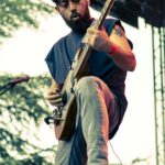Guitarist of Planet Of Zeus performing live at Kave Fest. Tree in the background.