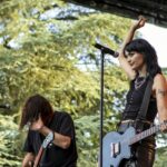 Kitty A. Austen of Saint Agnes performing live at Kave Fest. Trees in the background.