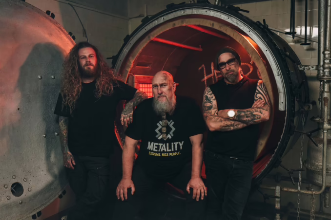 Three men facing the camera in a dark tunnel