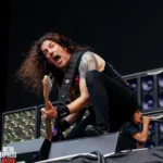 Frank Bello, bass player for Anthrax, performing live. He is screaming towards the audience.
