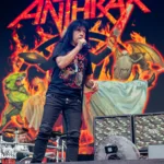 Joey Belladonna singer of Anthrax performing live in front of a display of their album cover, Cursum Perficio.