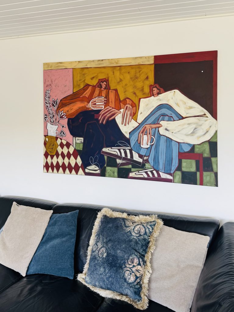 Maleri hængende på væg over sofa