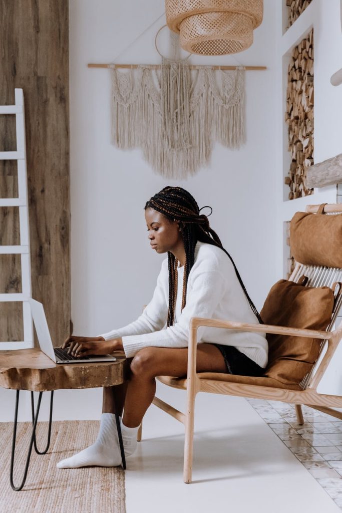 woman in white long sleeve shirt sitting on brown wooden chair