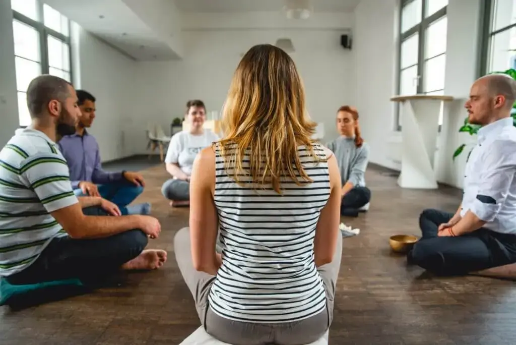 Ein Meditationslehrer, der eine Gruppe von Leuten schult, wie man meditiert, um unerwünschte Nebenwirkungen zu vermeiden.